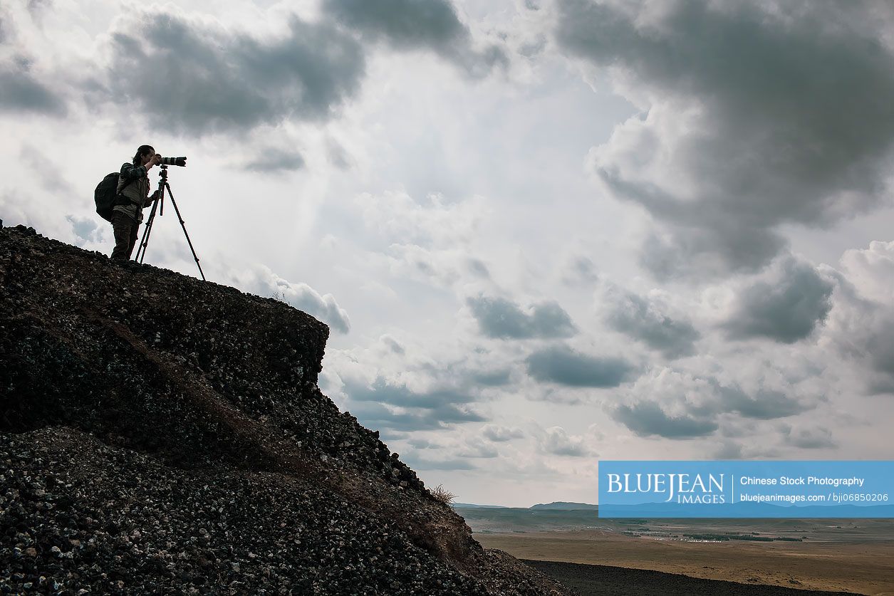 Chinese male photographer taking photos outdoors