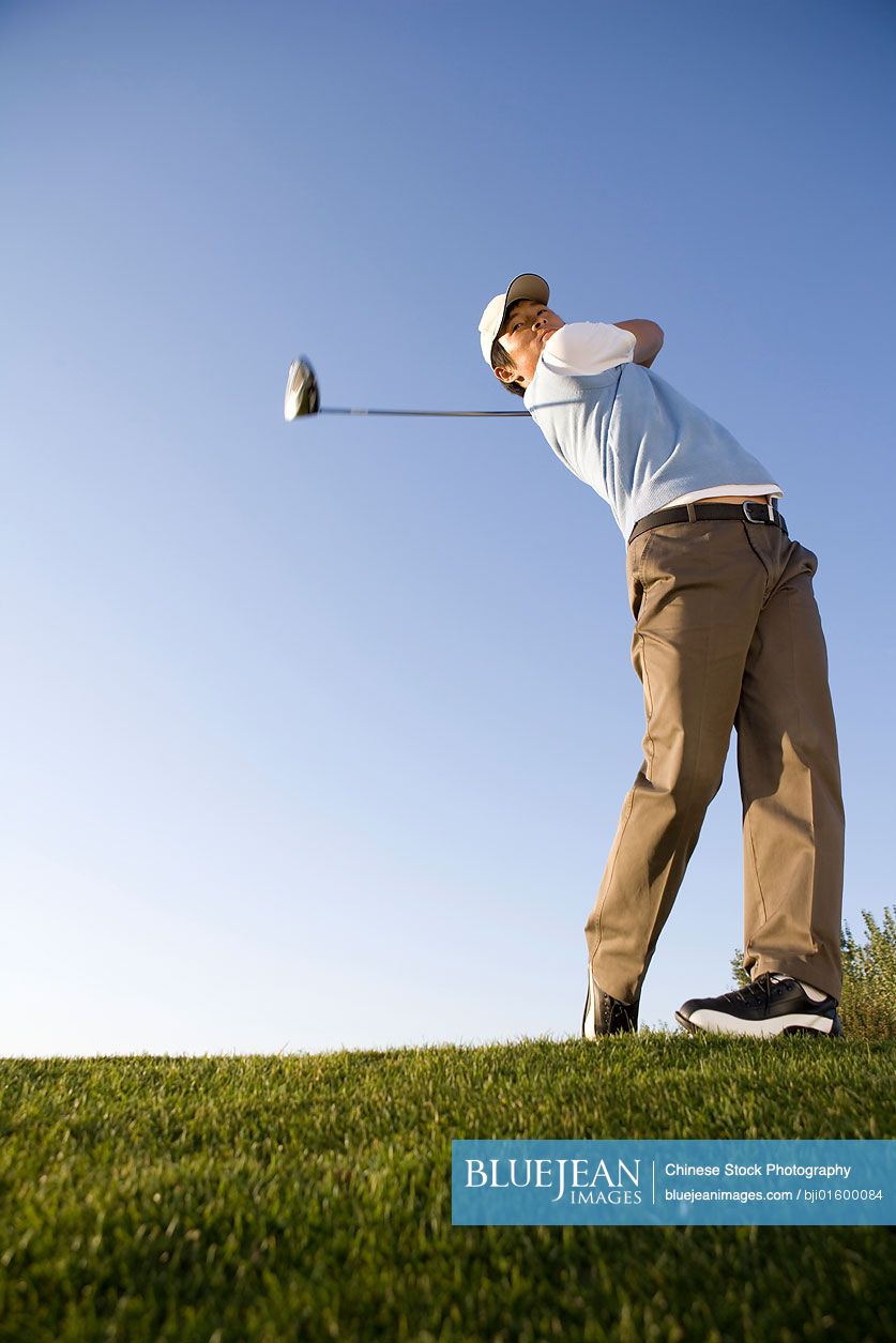 Chinese golfer teeing off on the course