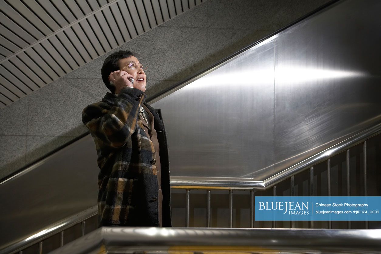 Chinese man talking on a cell phone and looking upwards