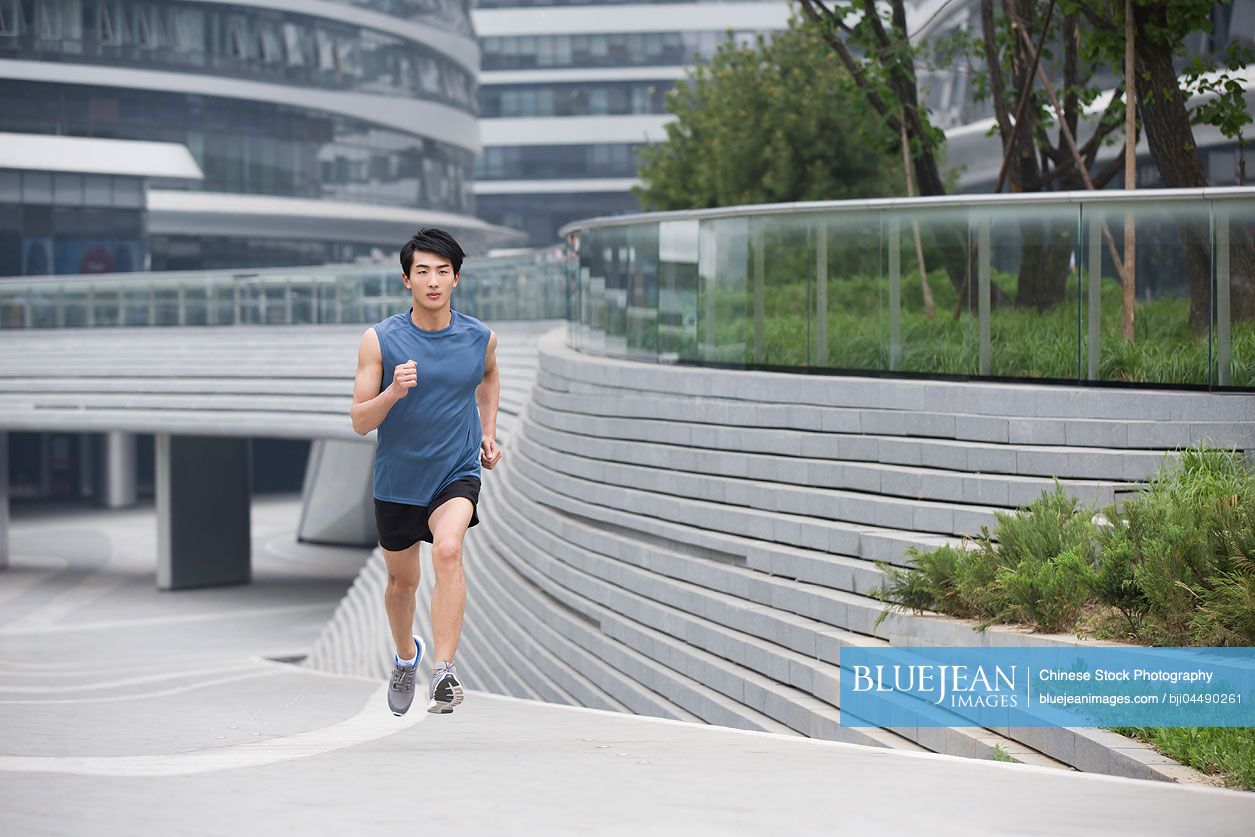 Young Chinese man running outside
