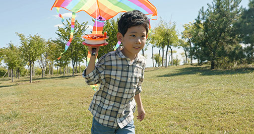 Happy Chinese boy running with kite on meadow,4K