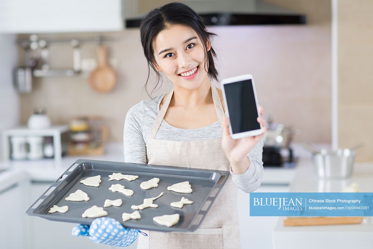 Young Chinese woman baking cookies in kitchen