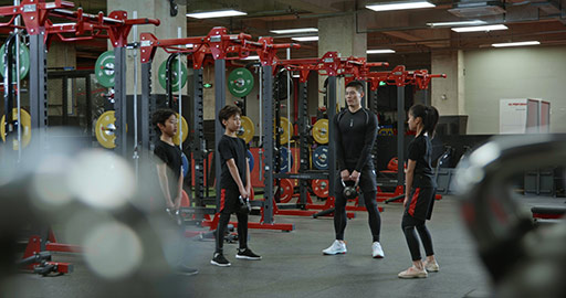 Active Chinese children having exercise class with their coach in gym,4K