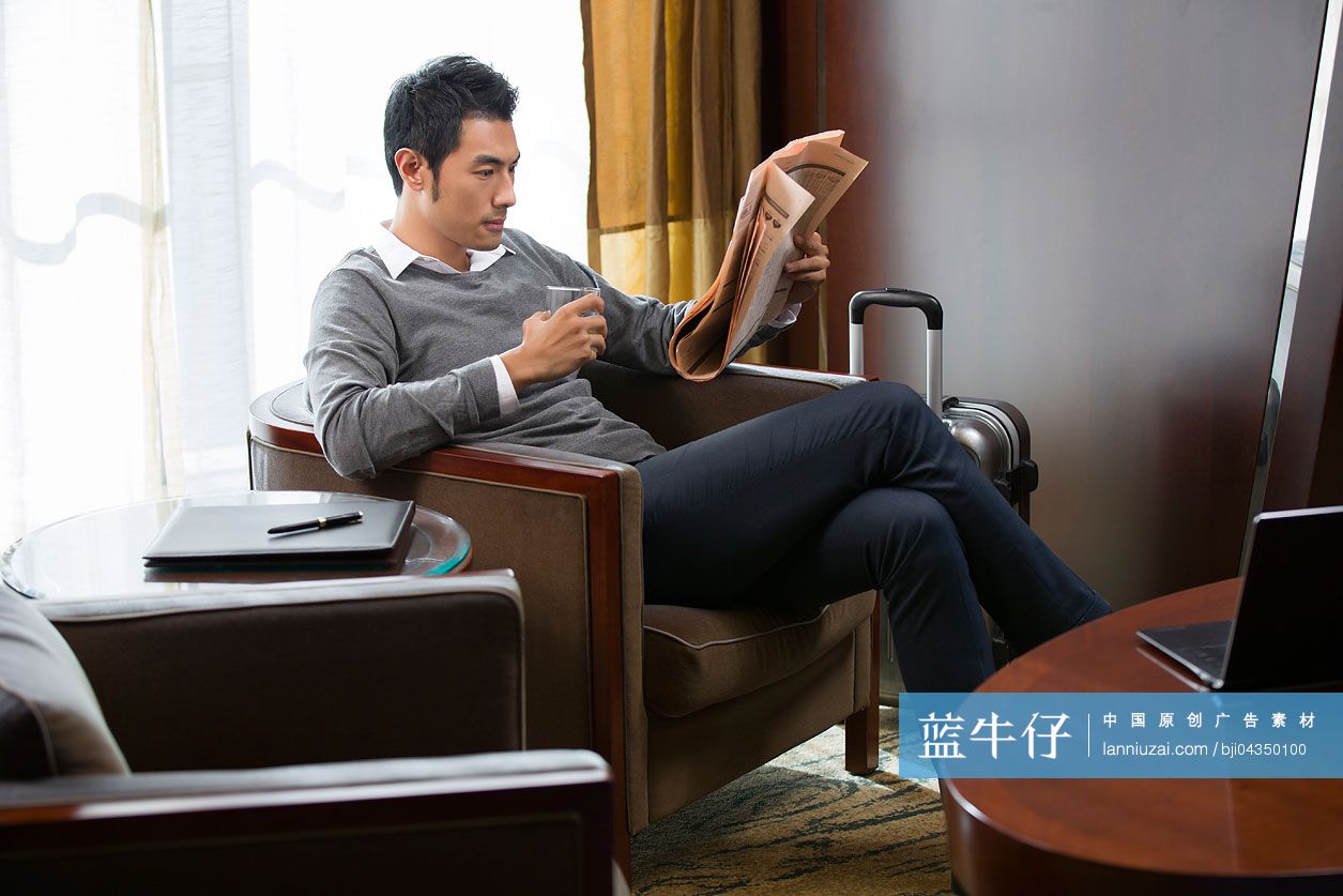 年轻商务男士在宾馆看报纸-蓝牛仔影像-中国原创广告影像素材