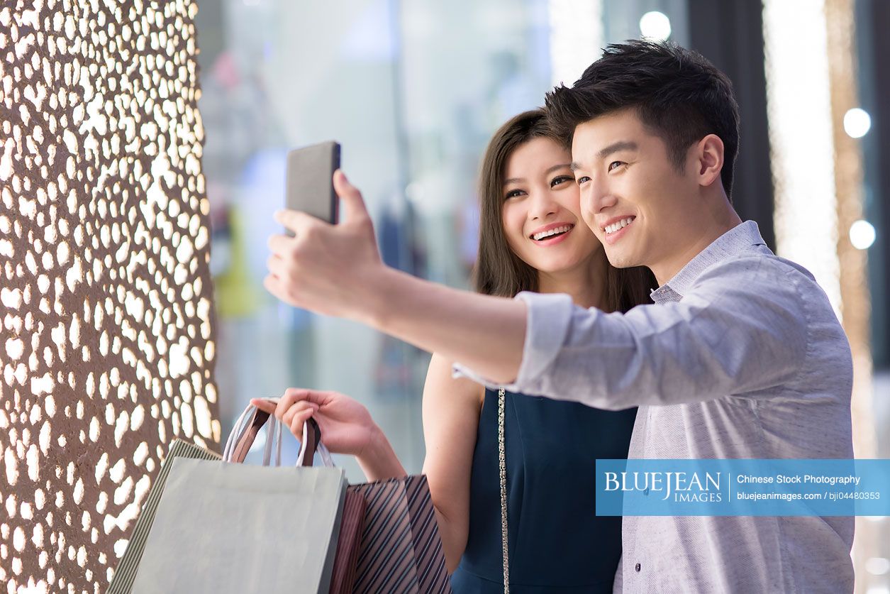 Happy young Chinese couple shopping