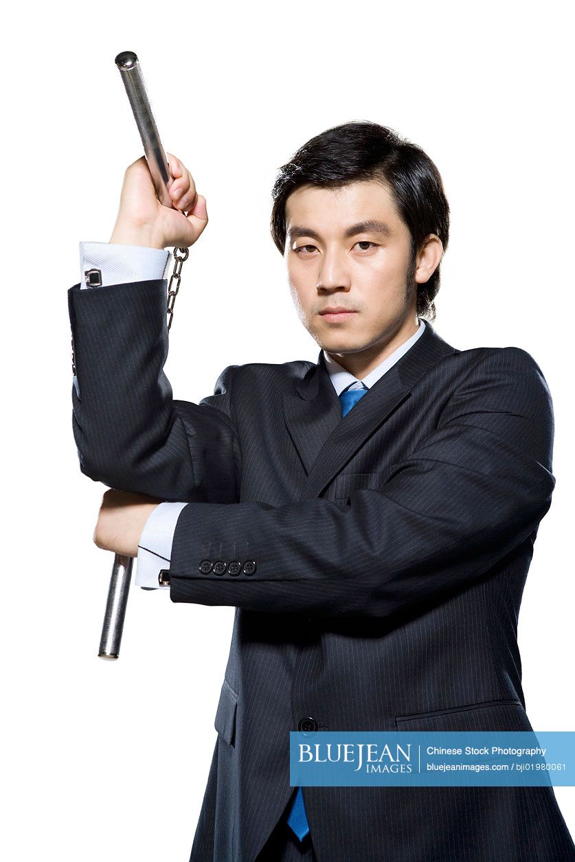 Chinese businessman holding nunchukas on white background