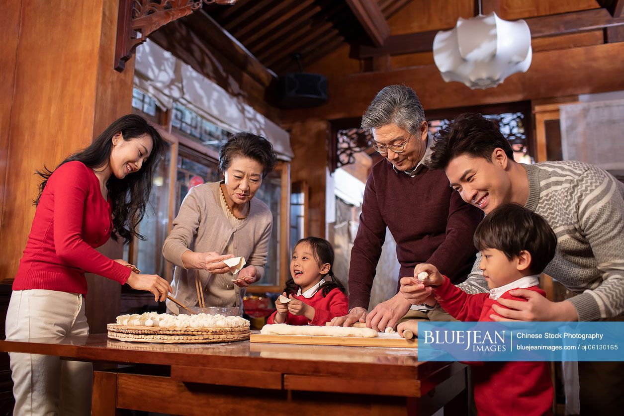 Happy Chinese family making dumplings