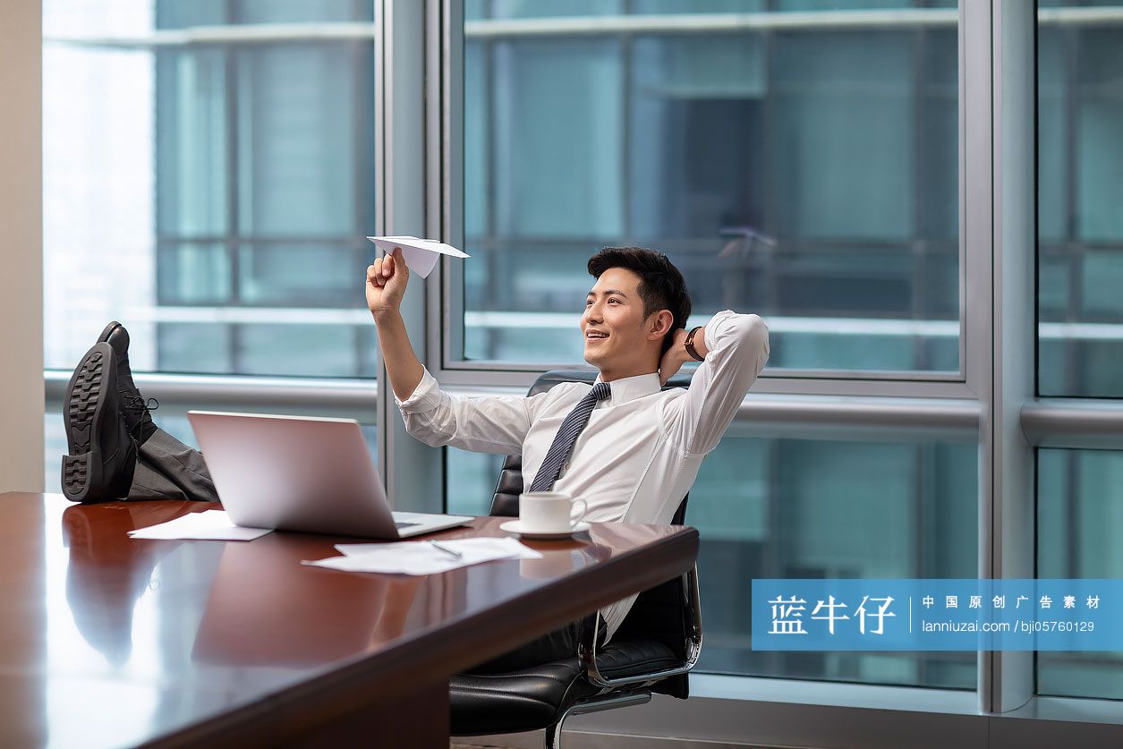 自信的商务男士在办公室扔纸飞机