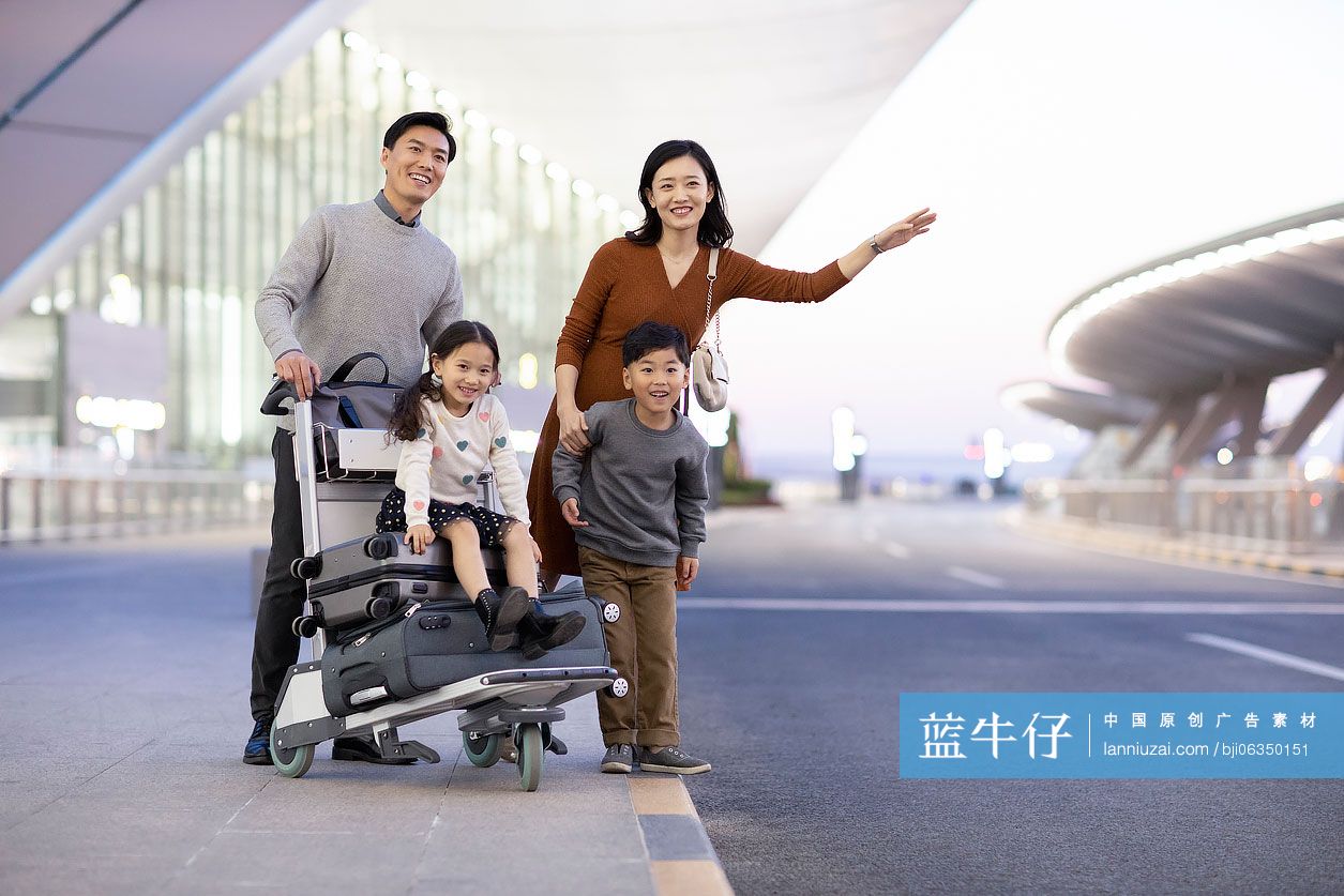 快乐的年轻家庭在机场打车