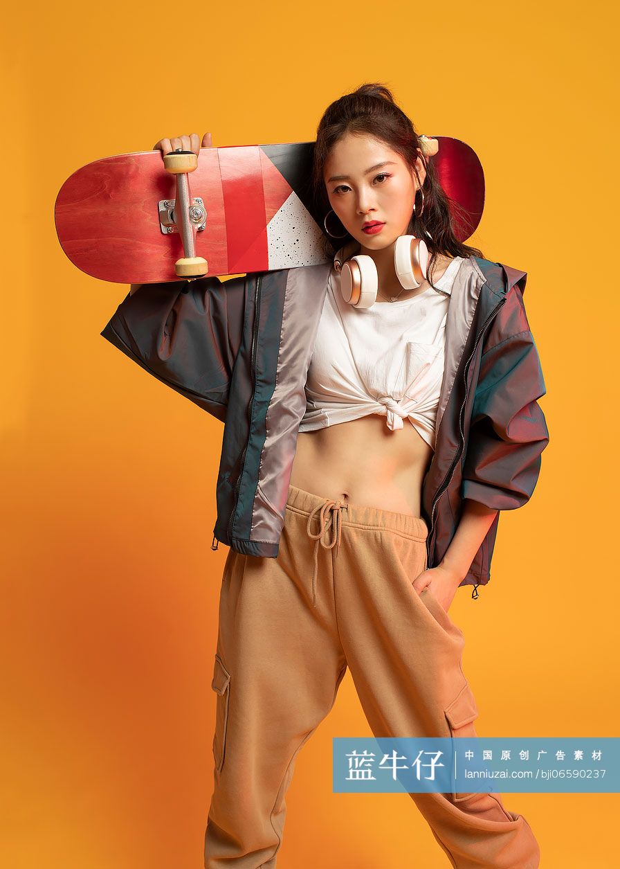 时尚的年轻女孩拿着滑板