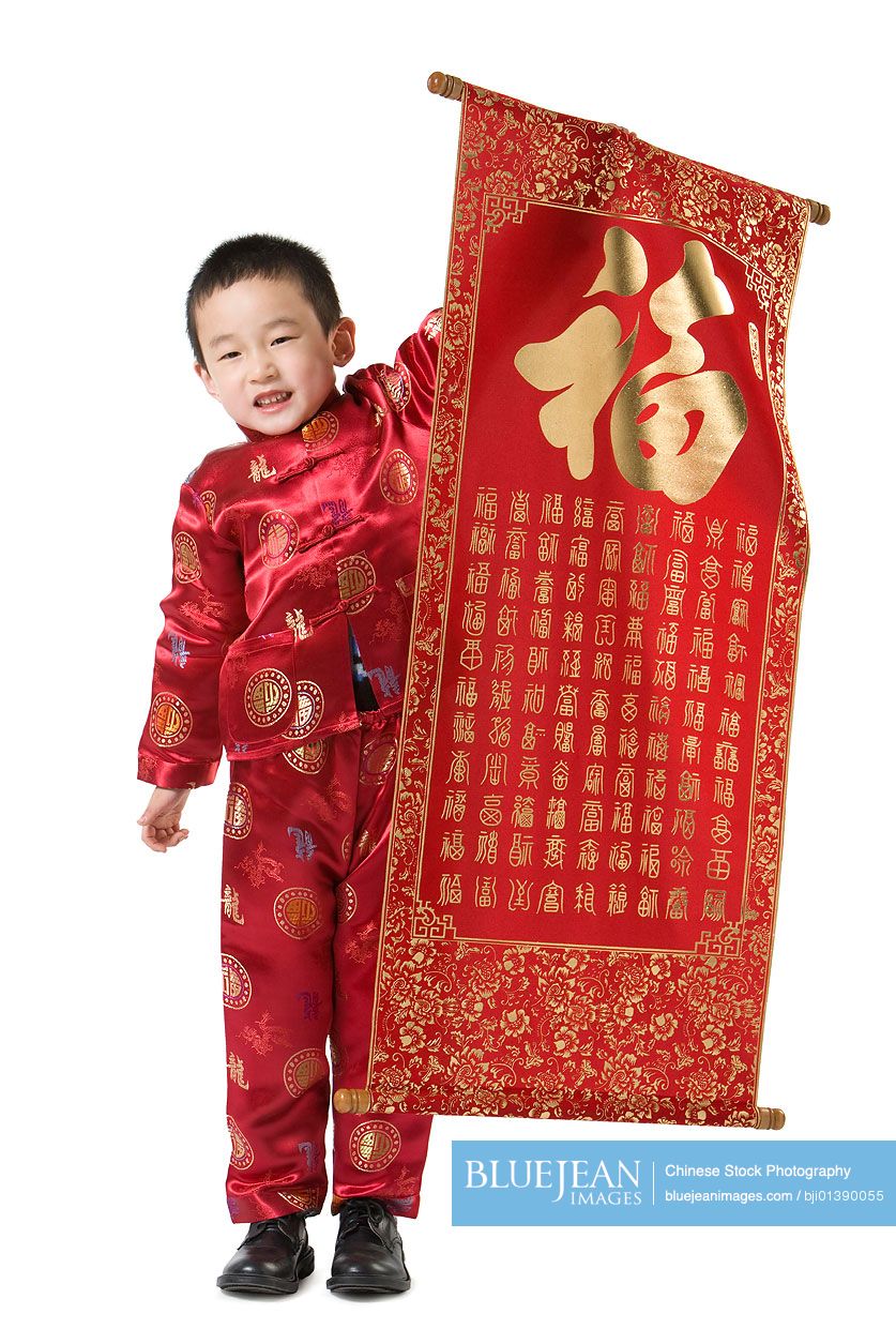 Boy in Chinese traditional clothes holding Chinese New Year scroll