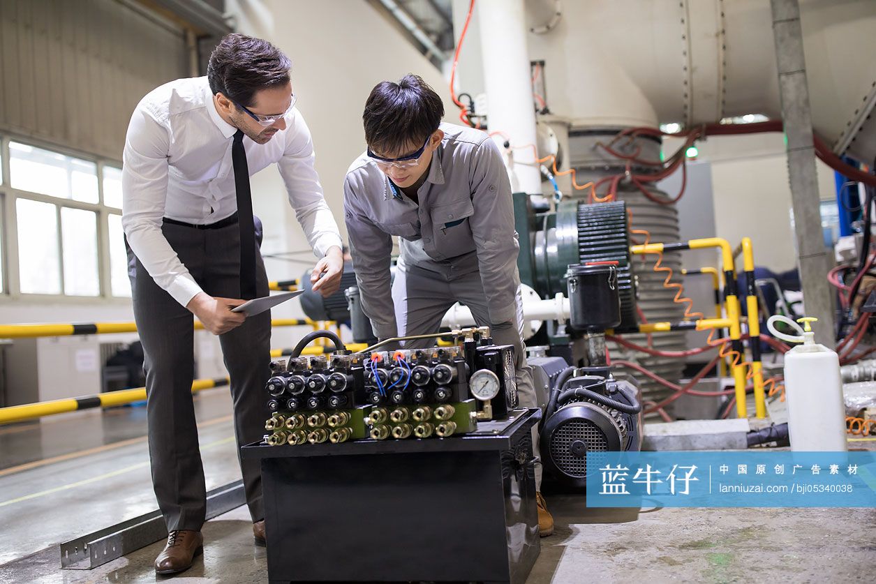 商务男士和工程师在工厂检查机器