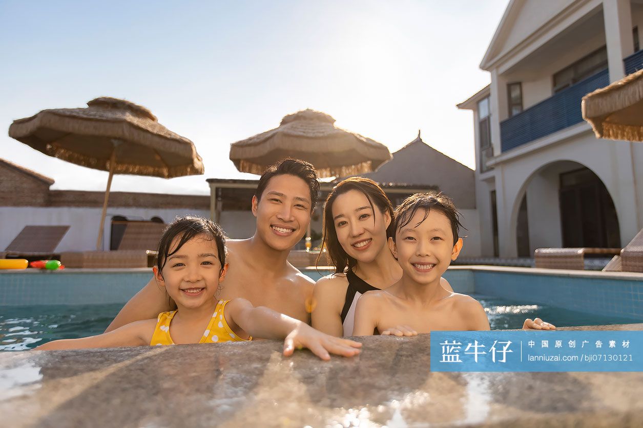 快乐的年轻家庭在泳池里嬉戏