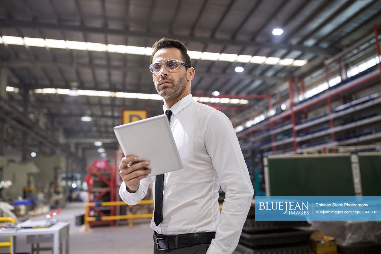 Businessman holding a digital tablet in the factory