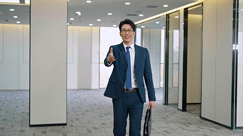 Confident Chinese businessman greeting in empty office