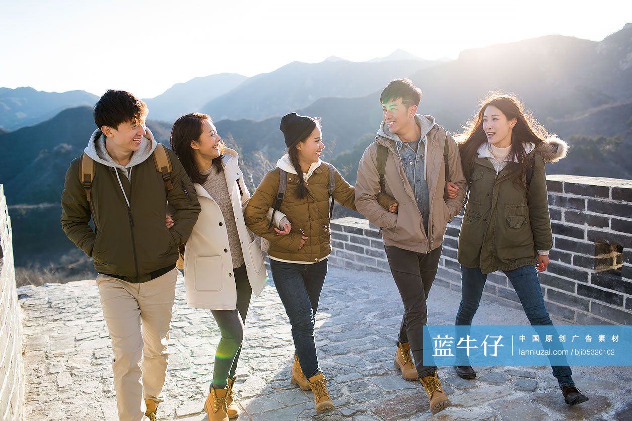 Happy young Chinese friends enjoying winter outing on the Great Wall