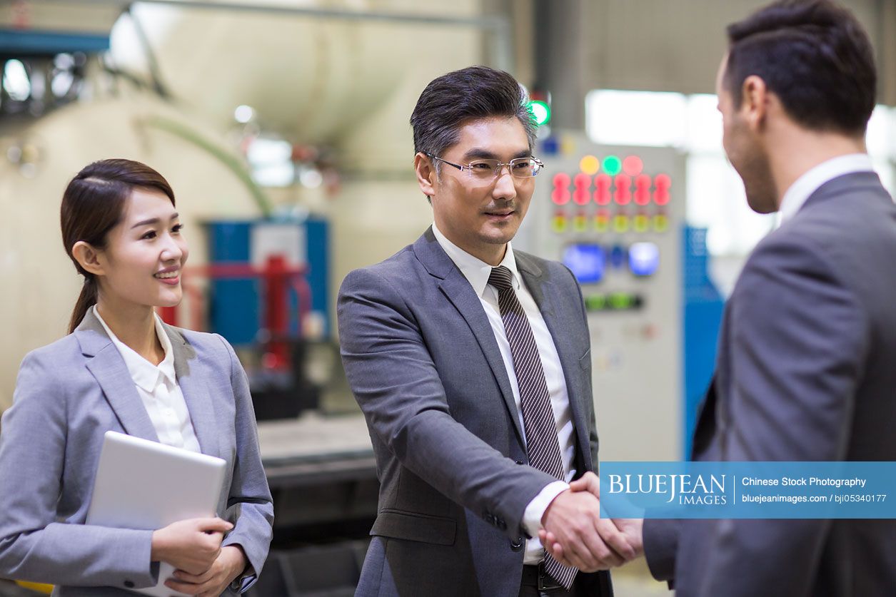 Business people shaking hands in the factory