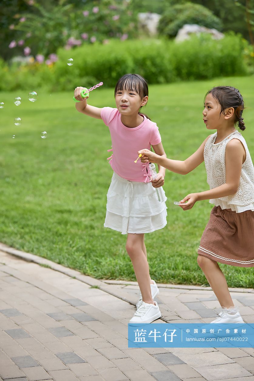 两个小女孩在公园吹泡泡
