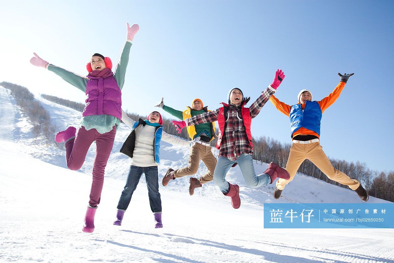 时尚青年男女在雪地跳跃