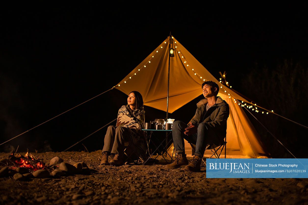 Happy young Chinese couple camping outdoors