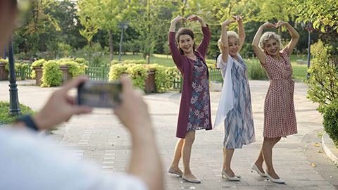 Senior Chinese friends taking pictures in park,4K