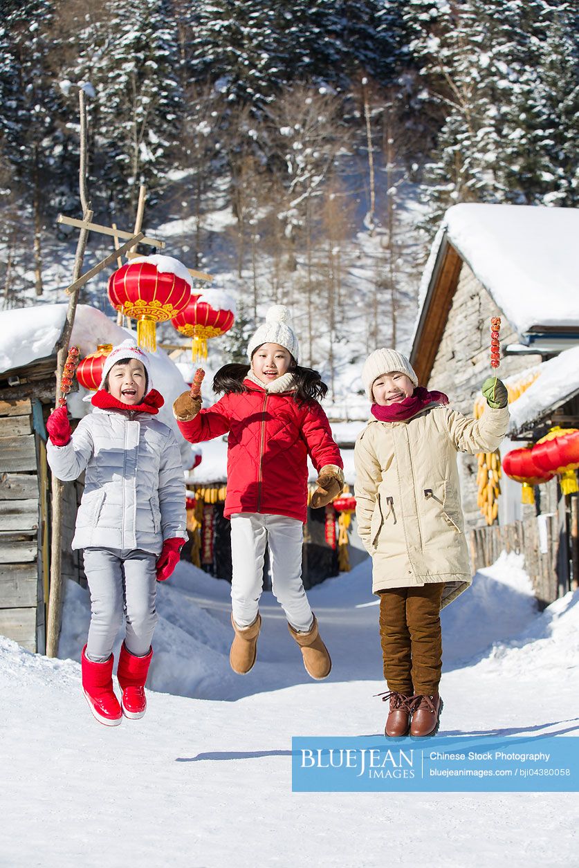 Happy Chinese children jumping with candied haws