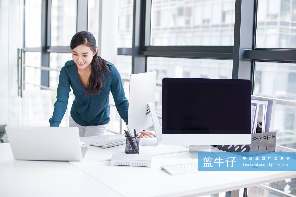 年轻商务女士在办公室使用笔记本电脑