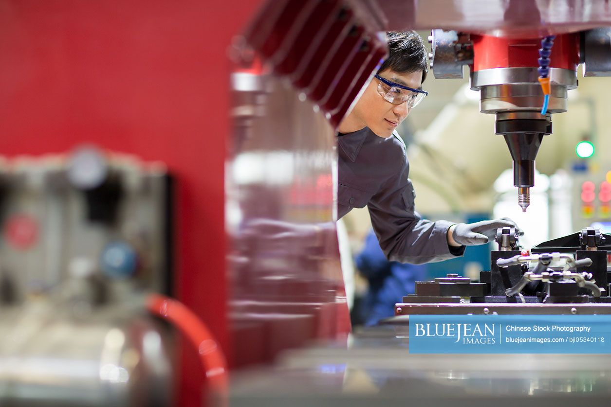 Young Chinese engineer working in the factory