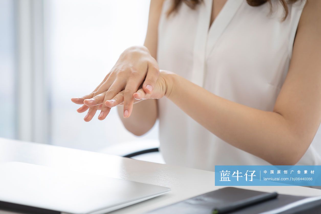 年轻的商务女士在办公室使用免洗洗手液