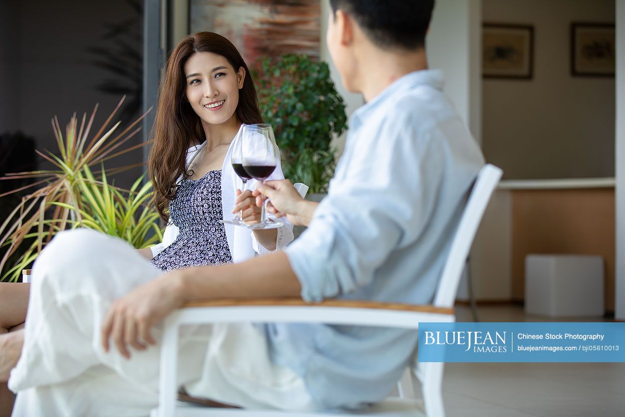 Young Chinese couple relaxing on balcony