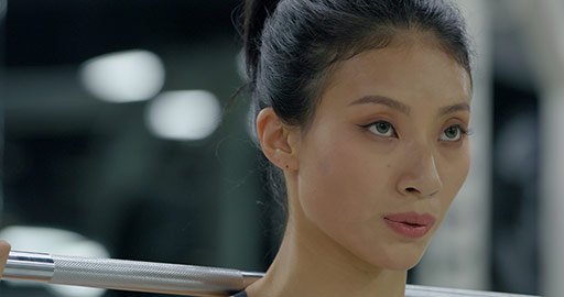 Young Chinese woman exercising with barbell at gym,4K