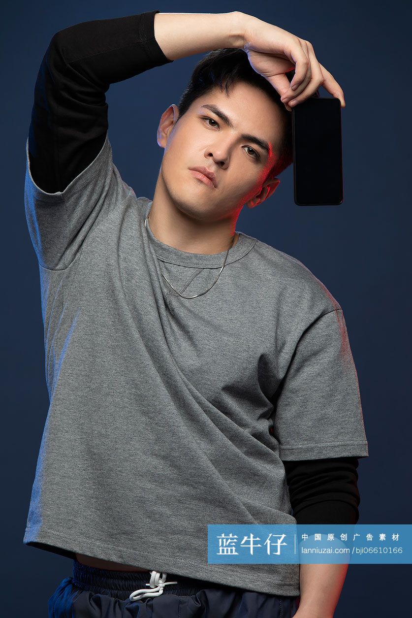 时尚的年轻男子展示手机