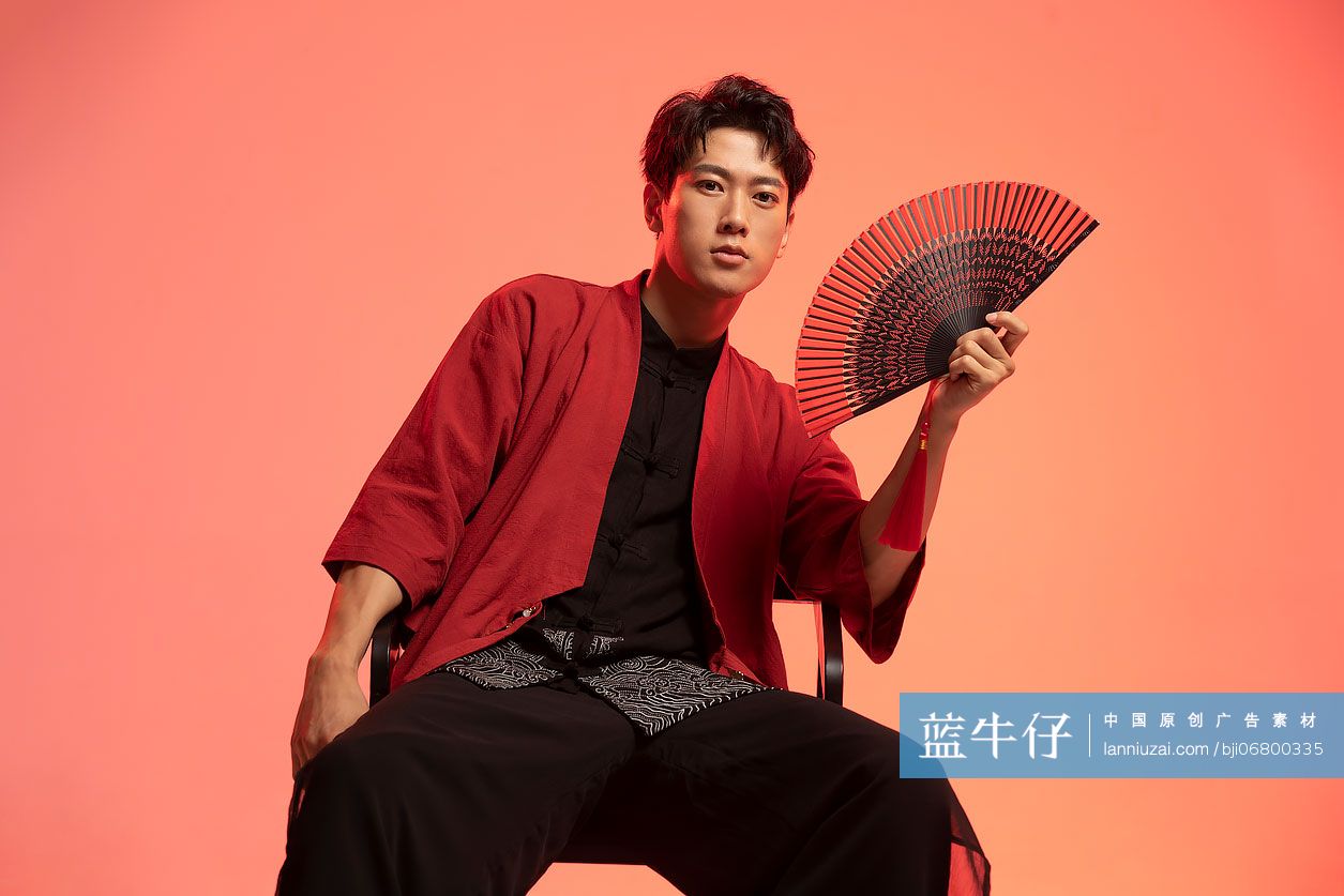 年轻国潮男子拿着折扇