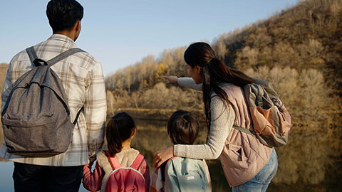 Cheerful young Chinese family enjoying the beautiful natural scenery