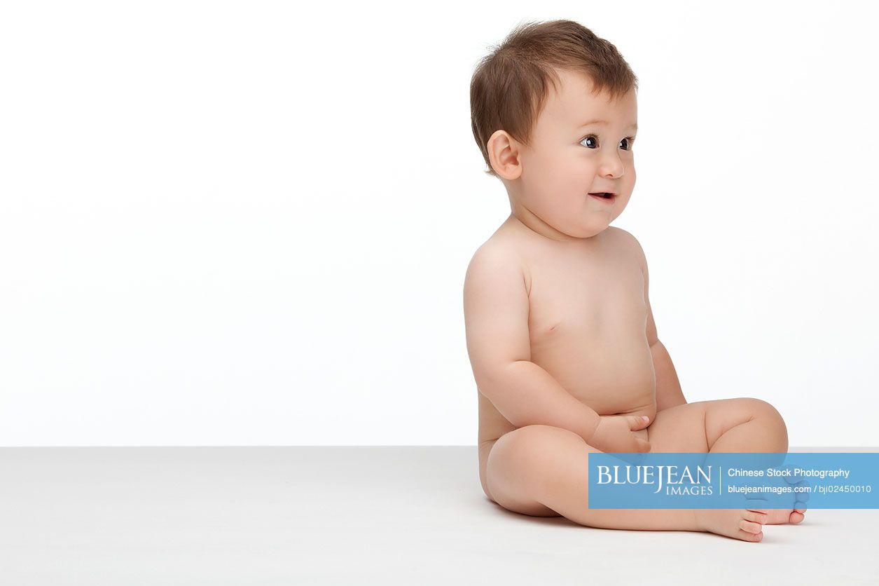 Studio shot of a cute Chinese baby boy looking away