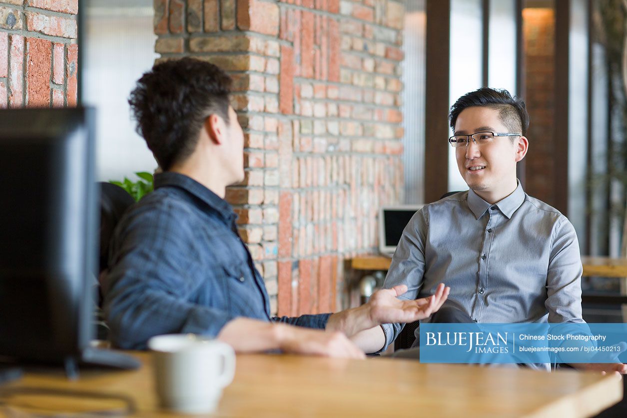 Chinese IT workers talking in office