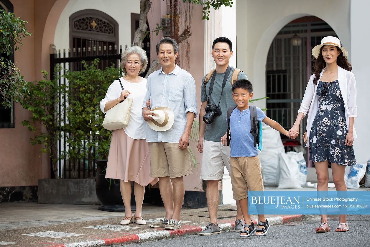 Happy Chinese family standing on street