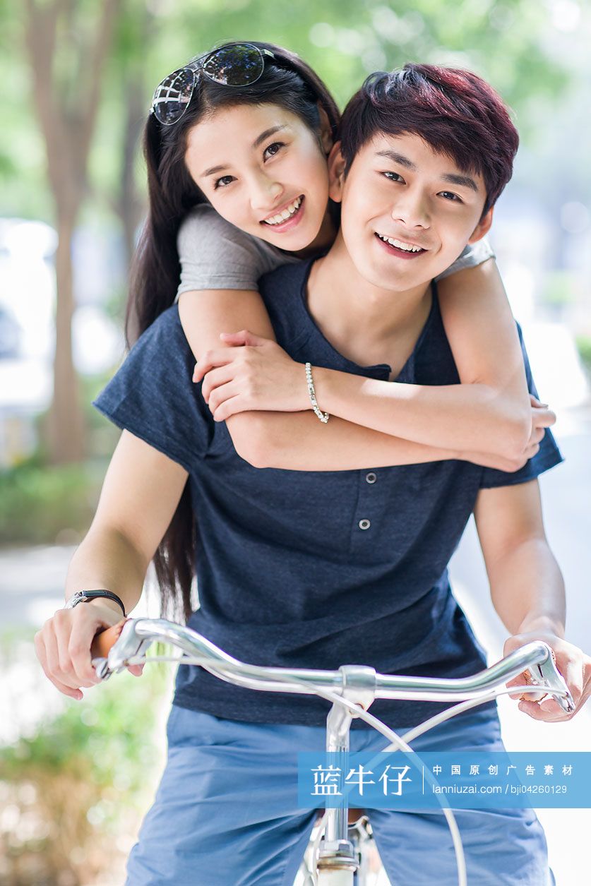 年轻大学生情侣在校园里骑车