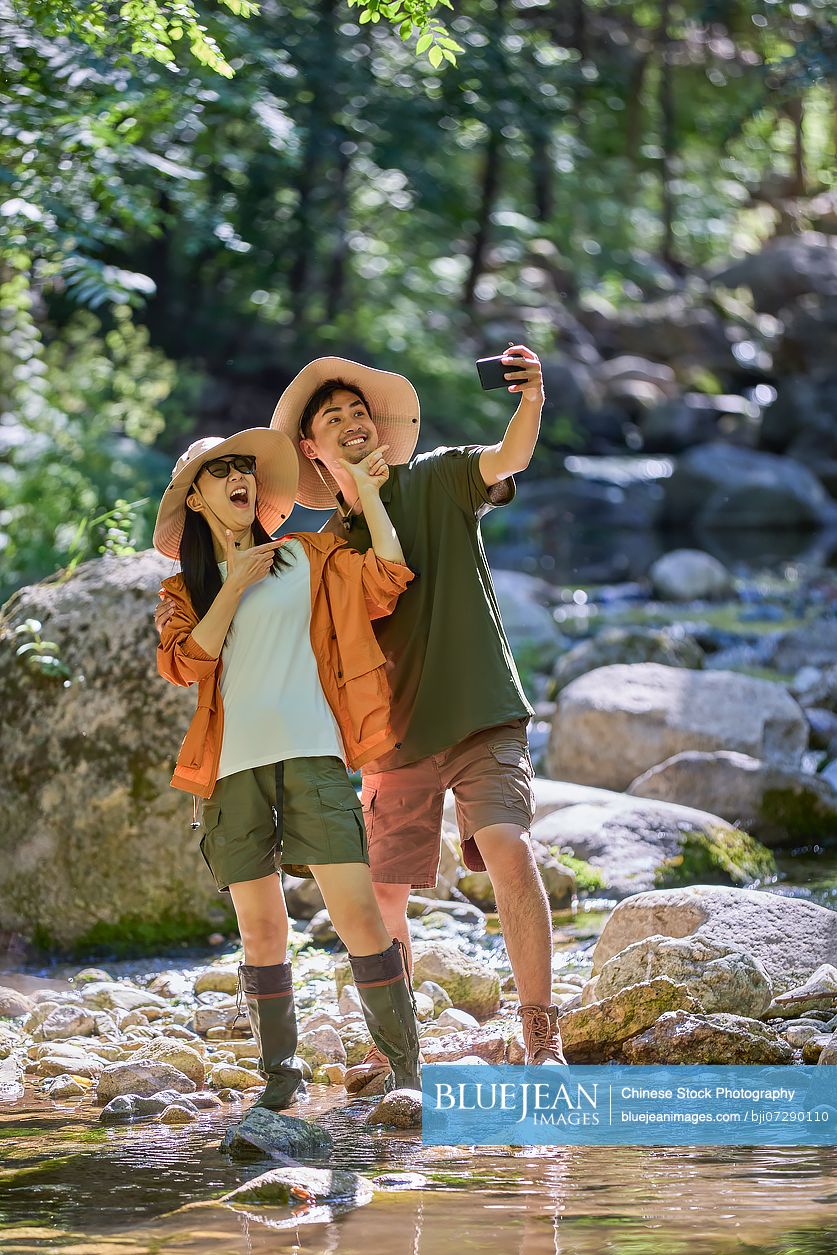 Happy couple enjoying themselves by the stream