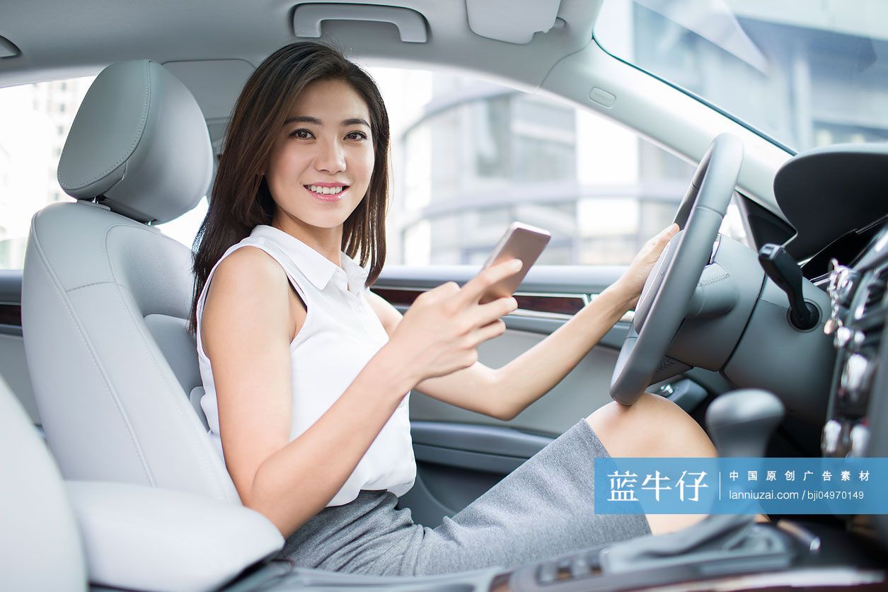 商务女士在车内使用手机