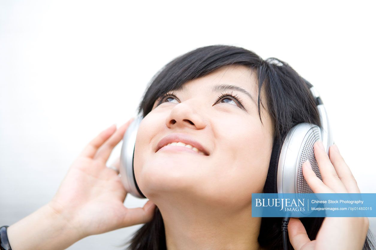 Young Chinese woman listening to music on headphones