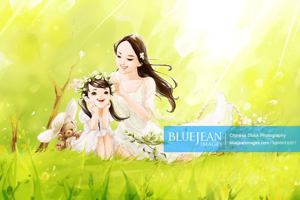 Happy Chinese mother and daughter sitting on grass