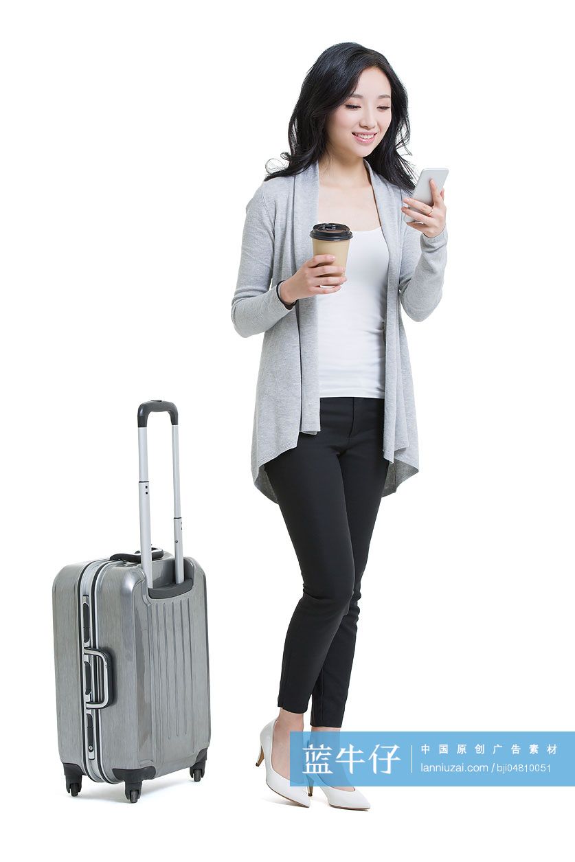 年轻女子带着旅行箱和手机旅行