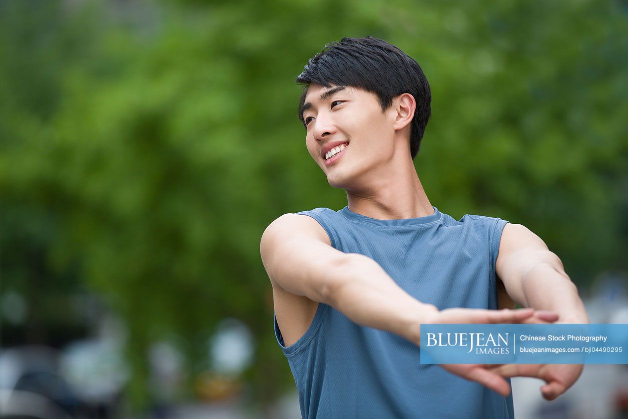 Young Chinese man stretching outside