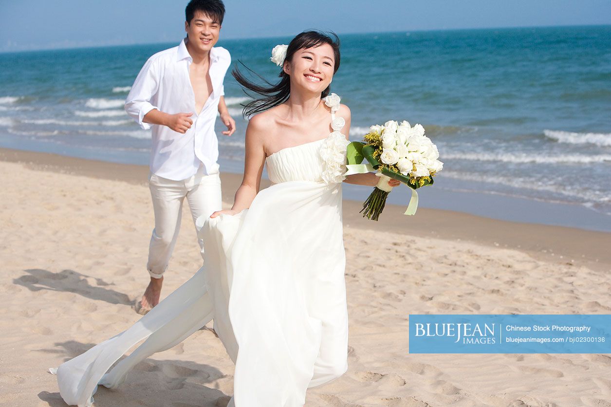 Happy Chinese newlyweds on the beach