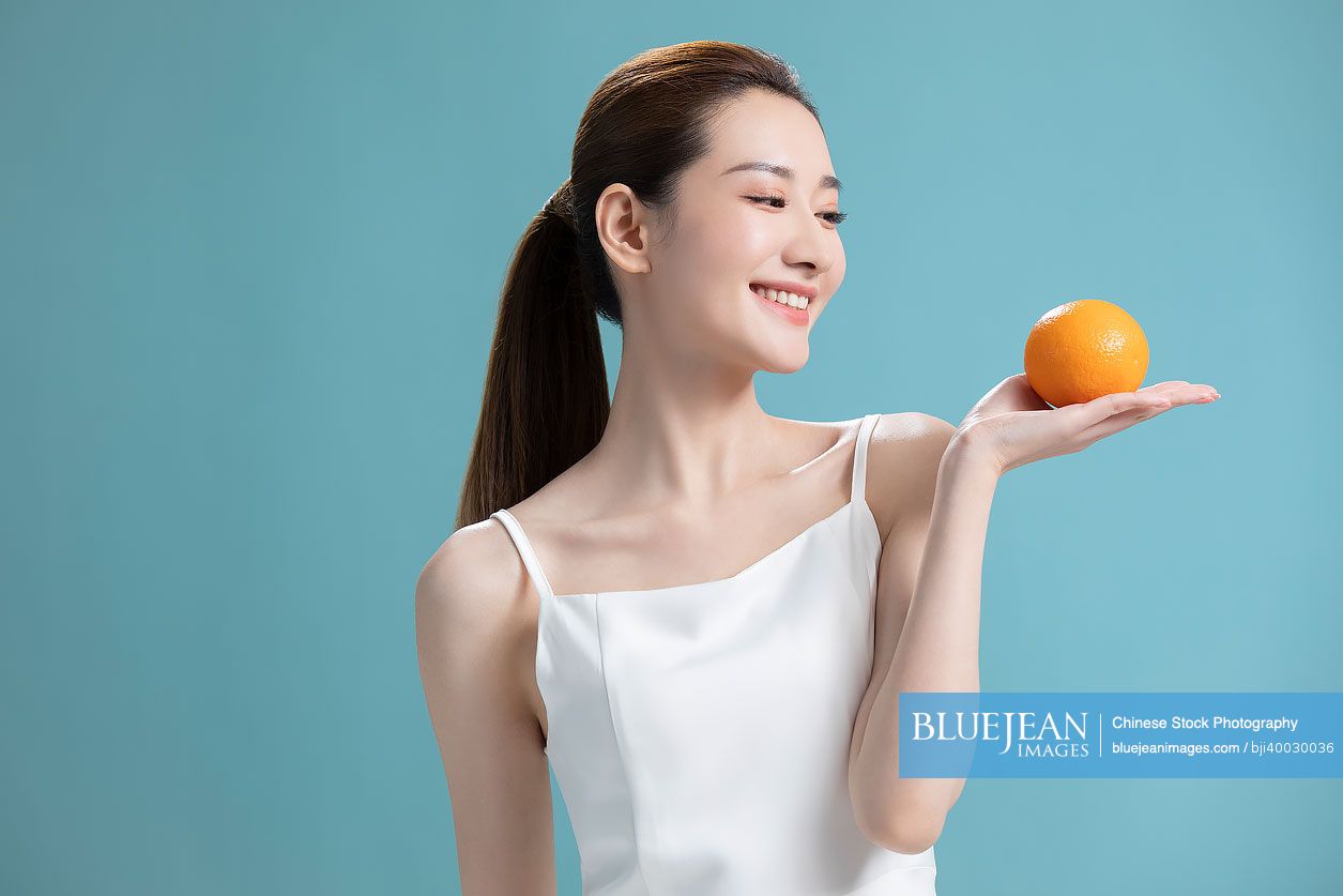 Beautiful young Chinese woman with oranges