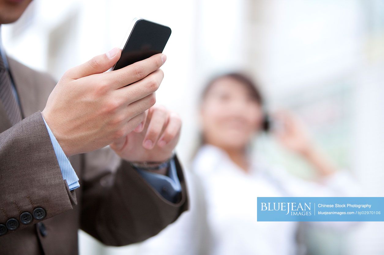 Young Chinese businessperson and cellphone