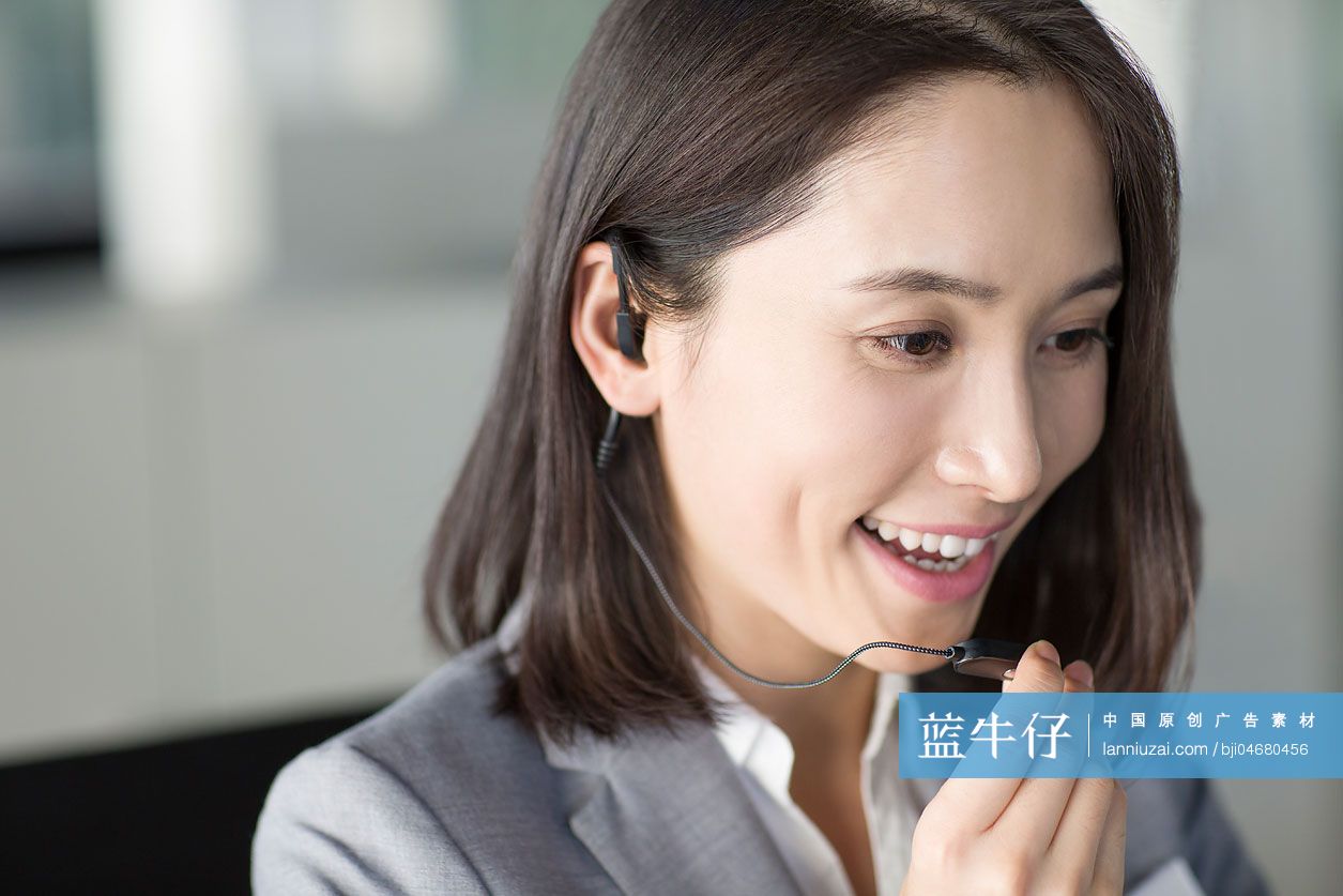 年轻商务女士戴着耳麦打电话