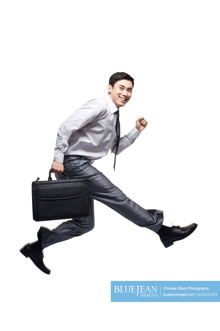 Young Chinese businessman jumping in the air