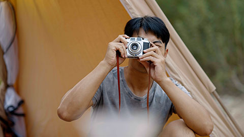 Young Chinese man taking photos outdoors